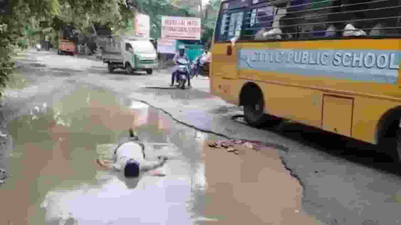 सड़क के गड्ढे में गद्दा-तकिया लेकर लेट गया कानपुर का यह मजबूर पिता kanpur protest